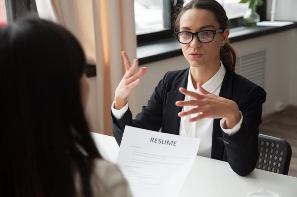 Confident female applicant in glasses talking at job - Interview