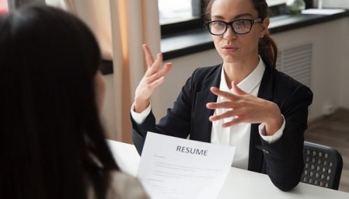 Confident female applicant in glasses talking at job - Interview